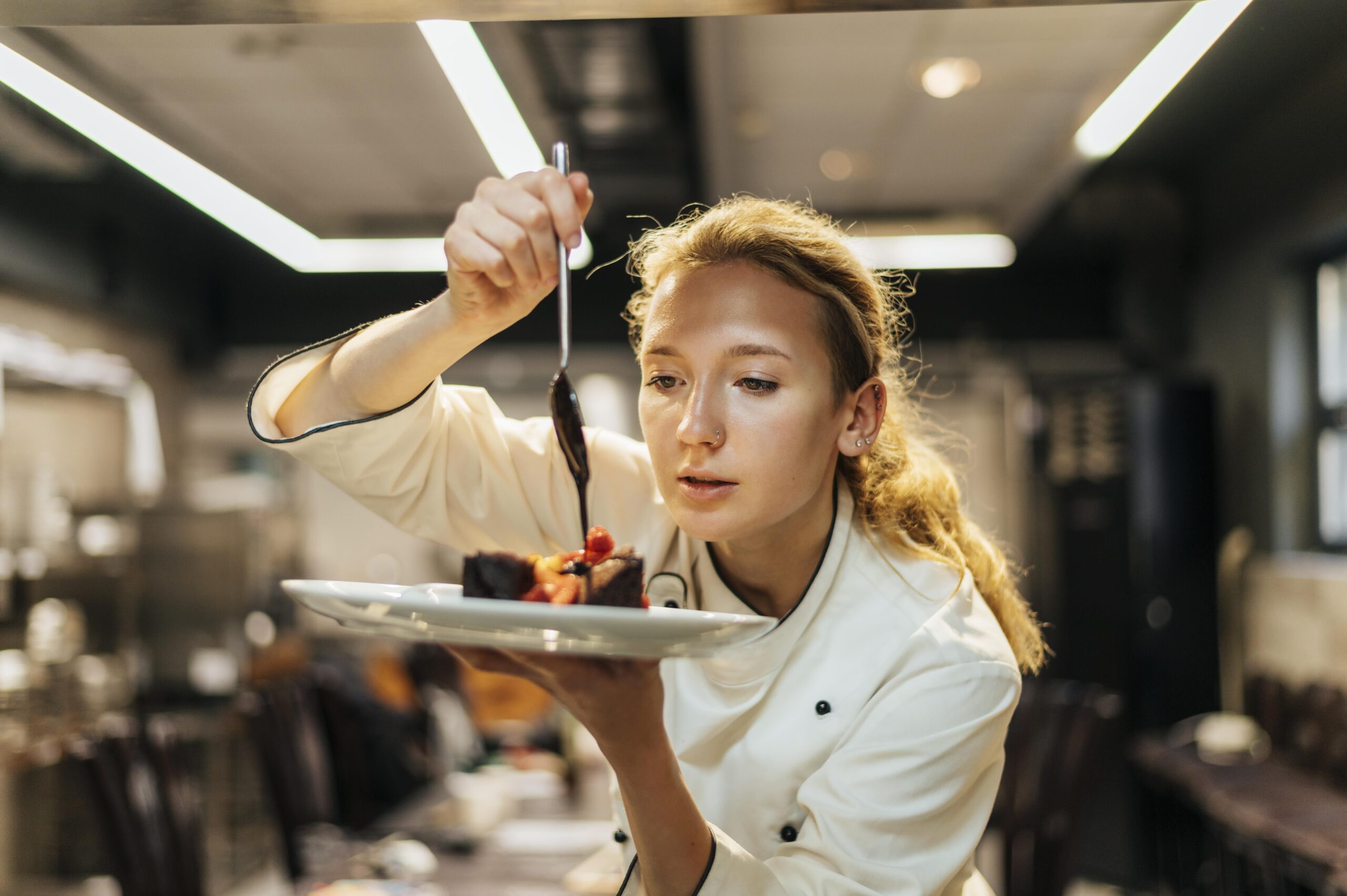 female-chef-carefully-pouring-sauce-dish